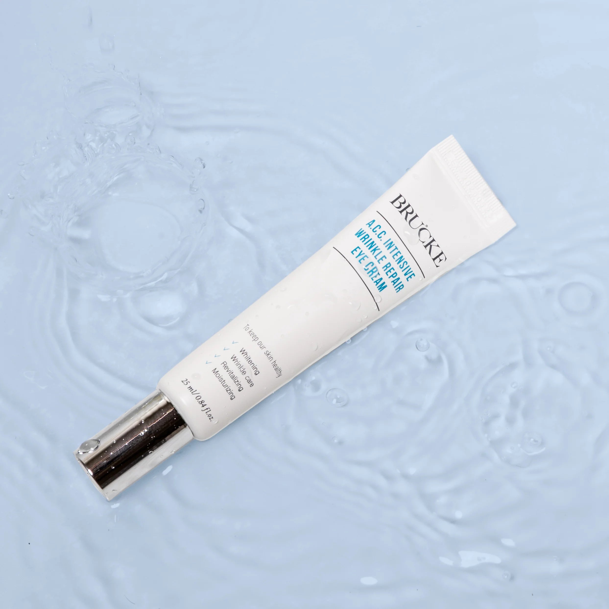 Brucke eye cream tube on a textured light blue background