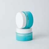 Two blue skincare containers with white lids on a light gray background